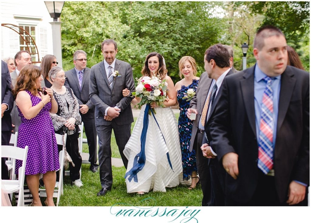 bride walking down the aisle at the inn at millrace pond