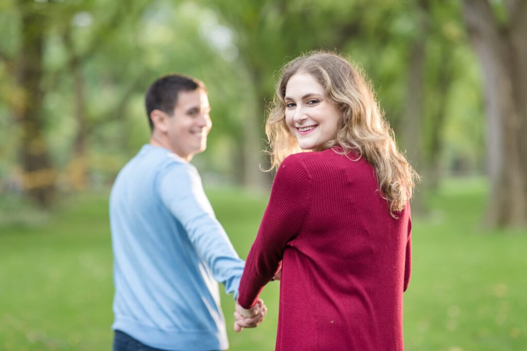 bride looking back at the camera as she holds hand with groom