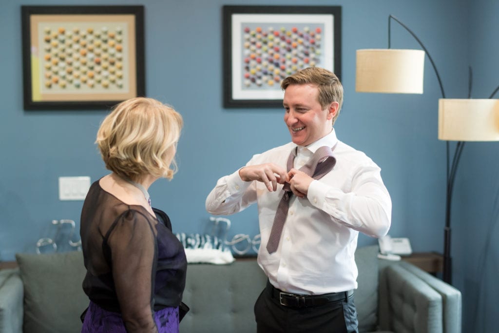 grooms mother helping him get ready for his wedding