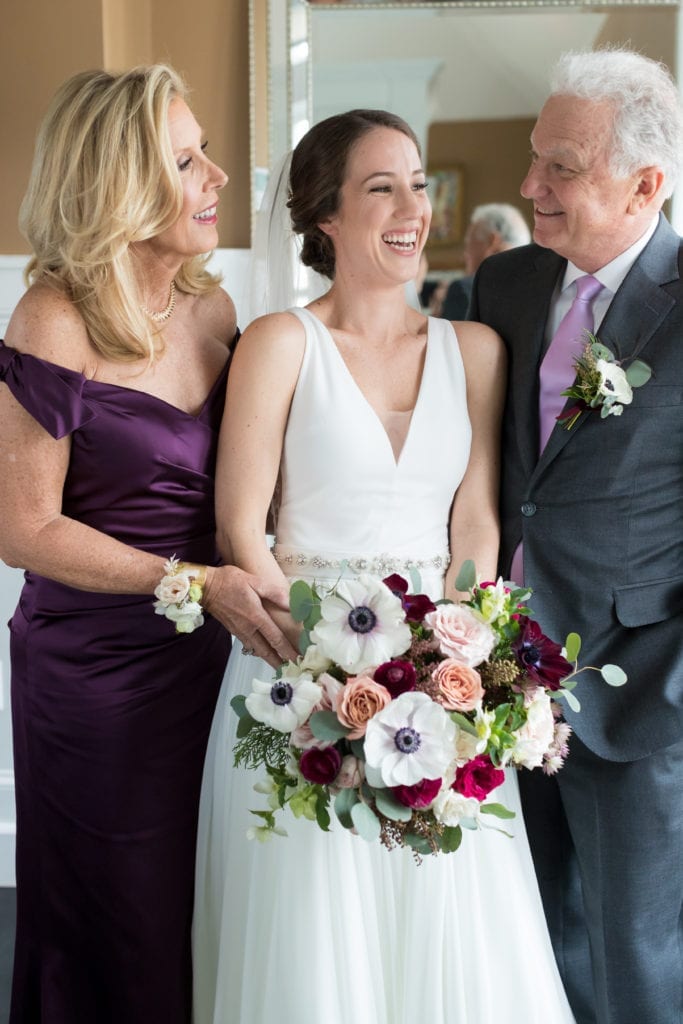 bride and groom laughing with her parents