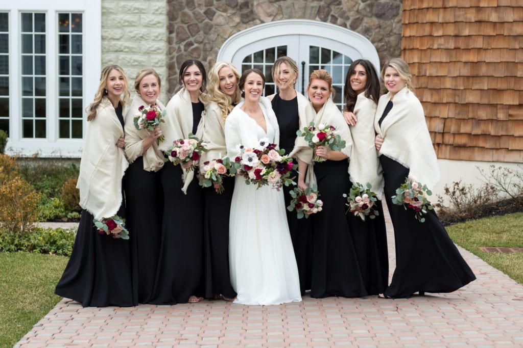 bride and bridesmaids posing in their shrugs 