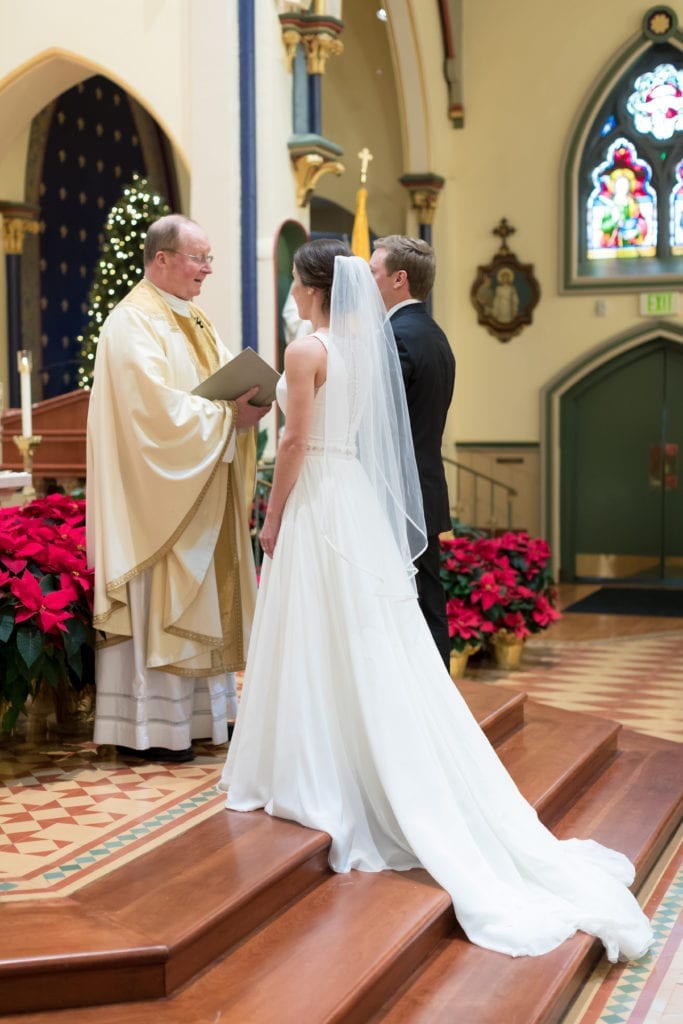 Priest reading bride and groom their vows