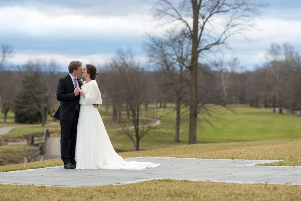 bride and groom kissing on golf course