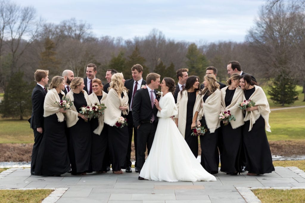 bride and groom and wedding party laughing