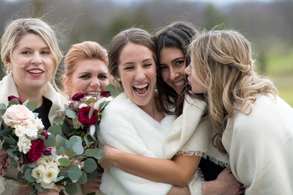 bride with her bridesmaids laughing