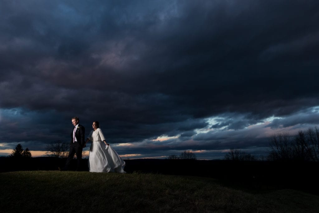 bride and groom walking across the country club grounds at dusk