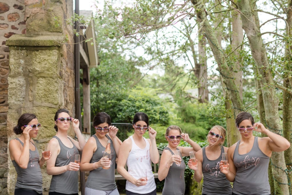 bride and bridesmaids drinking champagne in fun sunglasses