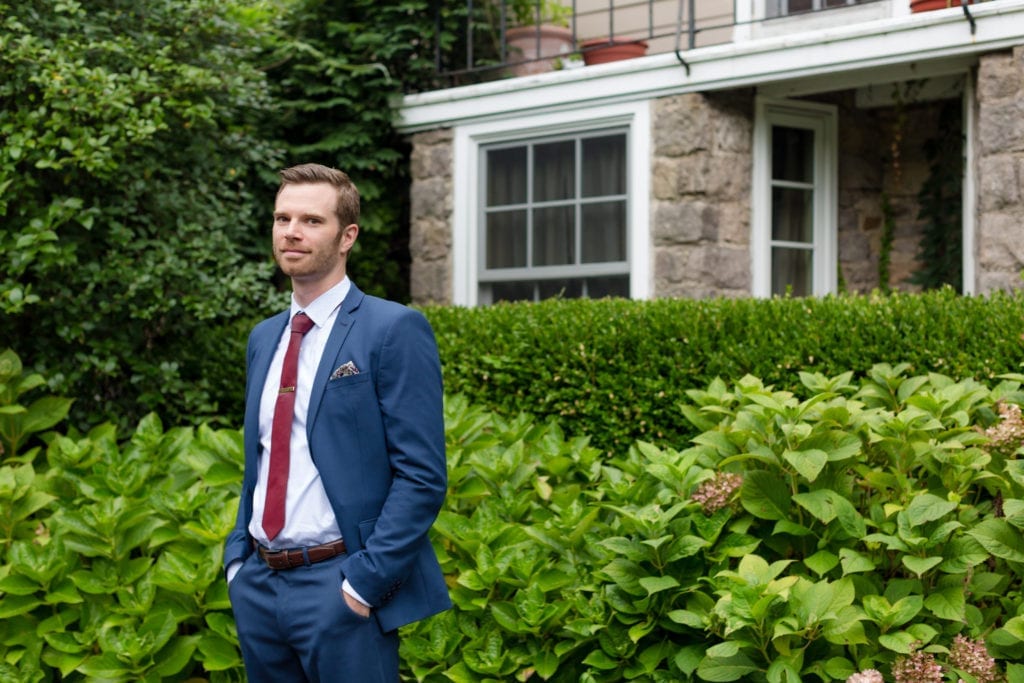 groom posing outside of hollyhedge estate