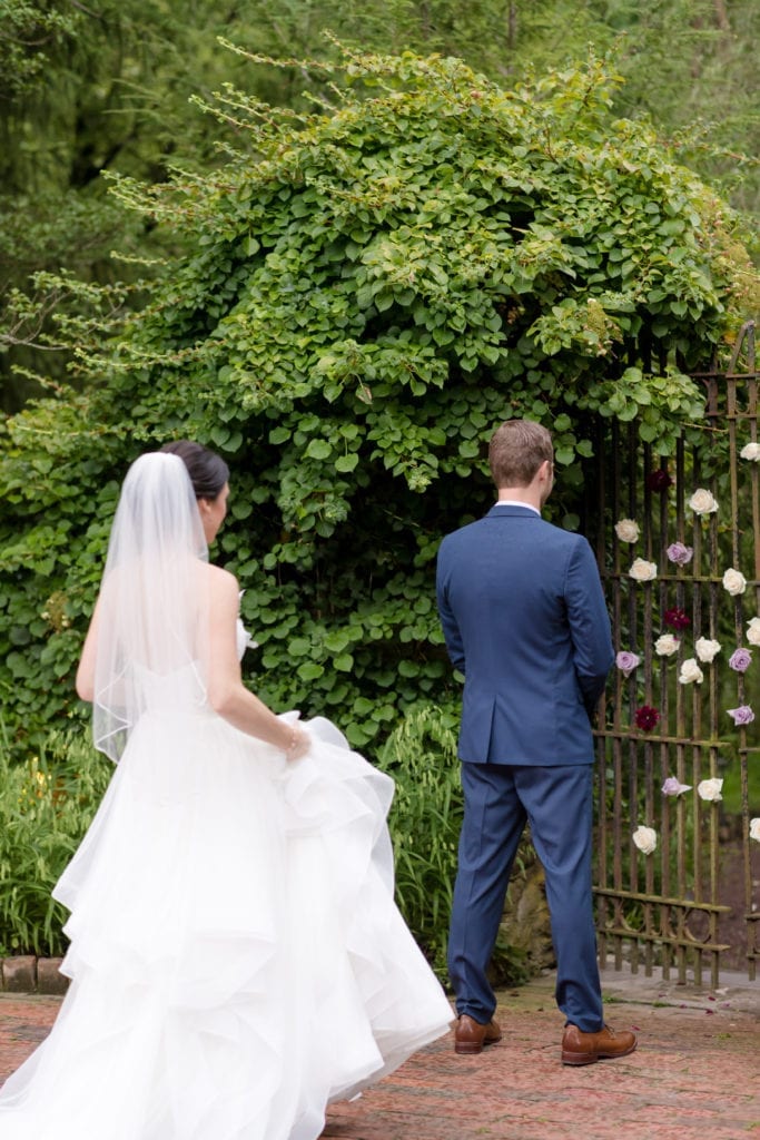 bride standing behind her groom waiting to reveal