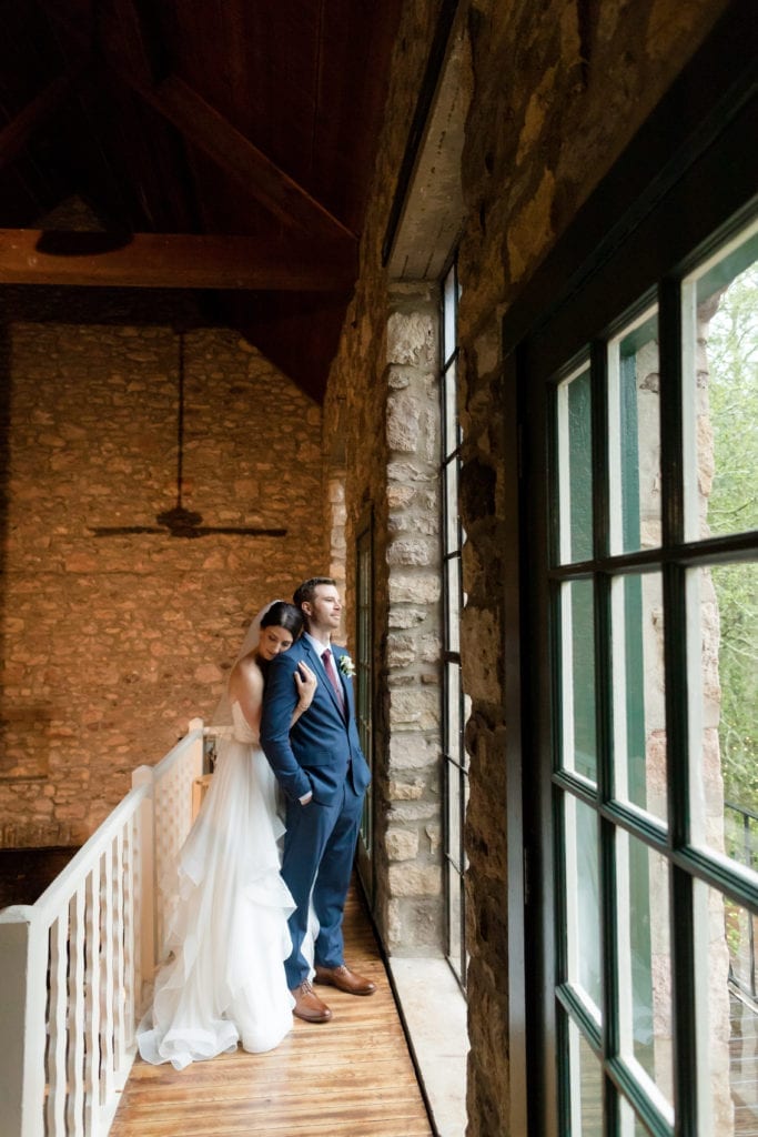 bride and groom looking out the window of holly hedge estate