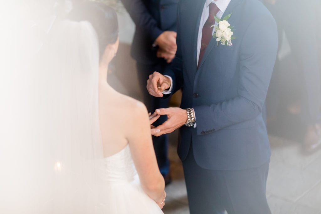 groom putting ring on his bride