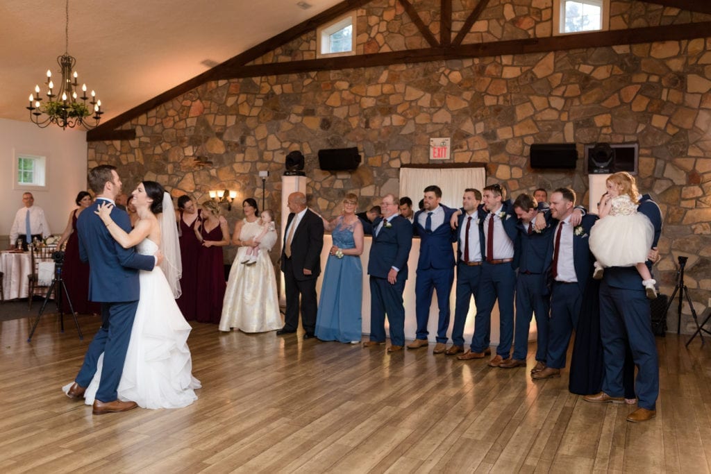 wedding party watching bride and groom dance