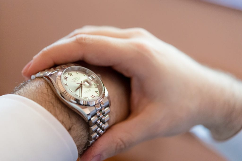 groom putting on his rolex watch for his wedding day