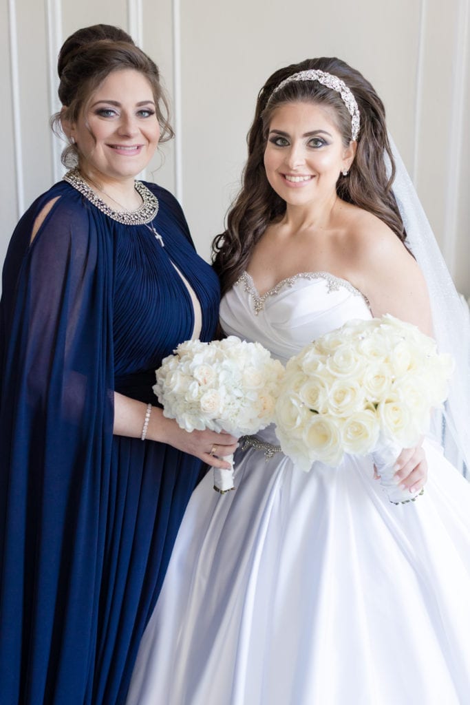 bride and maid of honor posing together with their bouquets 