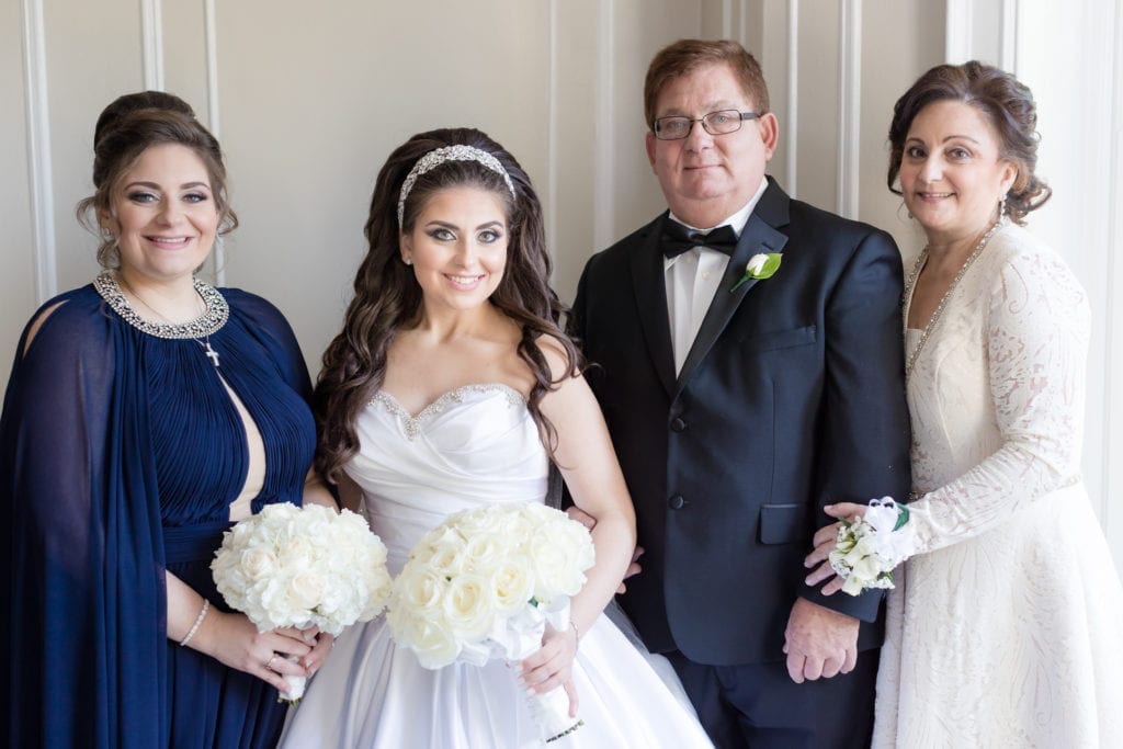 bride taking a photo with her family members