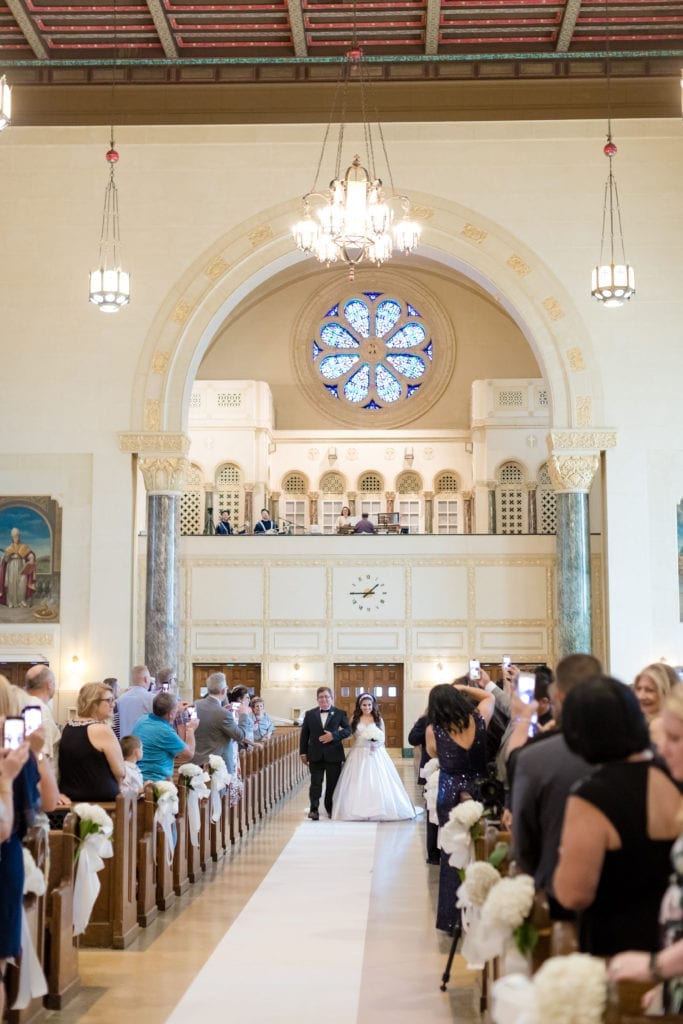 father of the bride walking his bride down the aisle