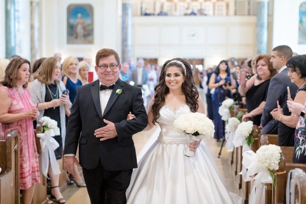 father of the bride and bride approaching the groom at the alter