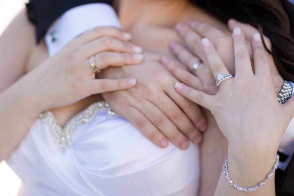 bride and groom showing their wedding bands