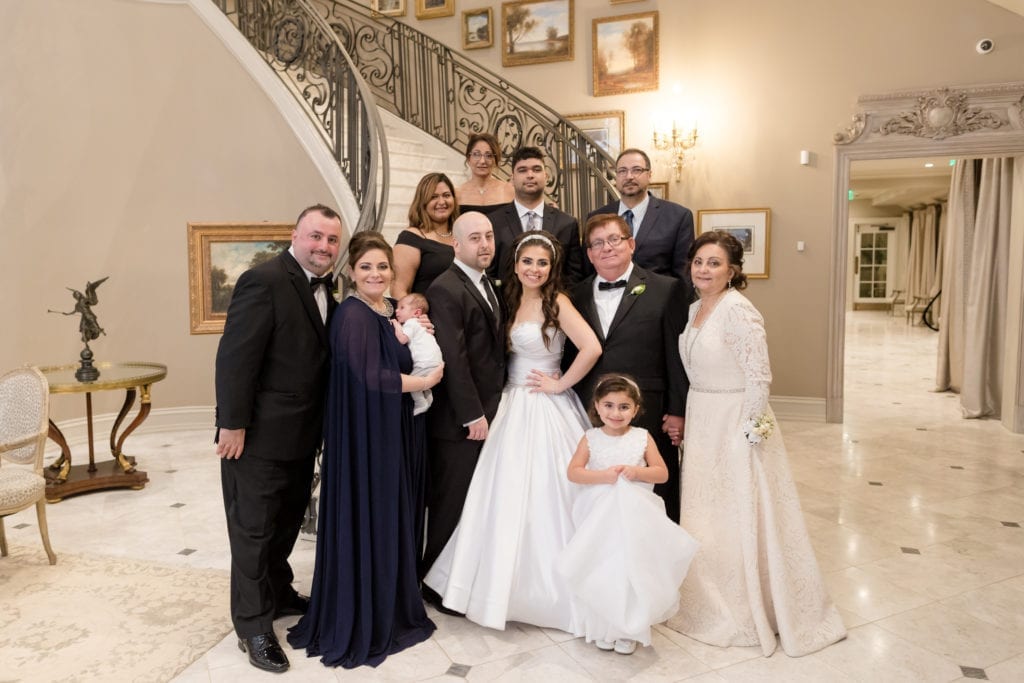 bride and groom posing with family