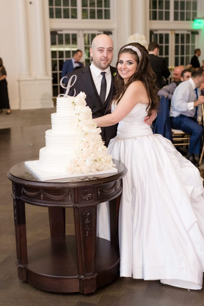 bride and groom cutting their 4 tiered Palermo bakery floral cake