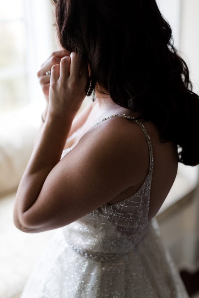 bride putting her earrings on