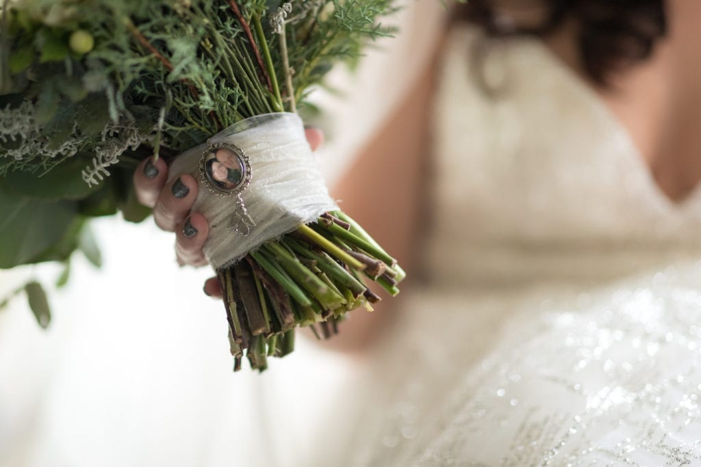 brides floral arrangement with locket picture of loved one