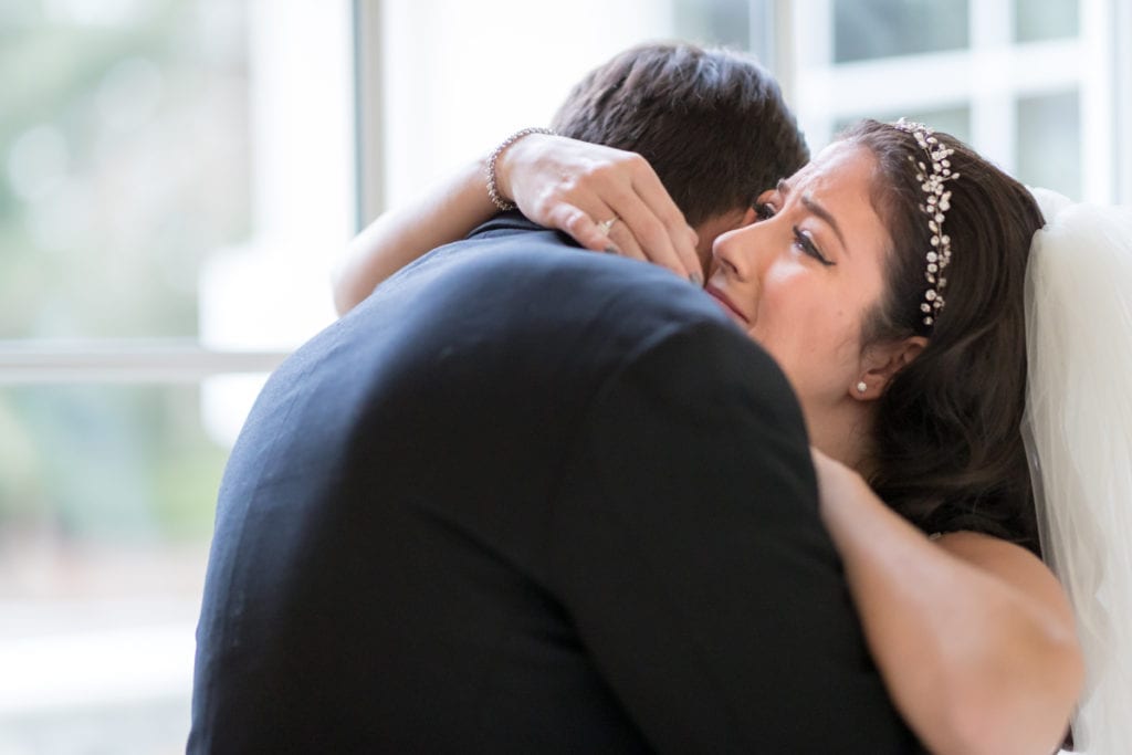 bride shedding a tear while hugging her father