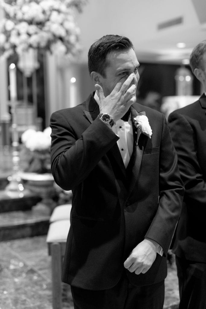 groom shedding a tear at alter, groom seeing his bride