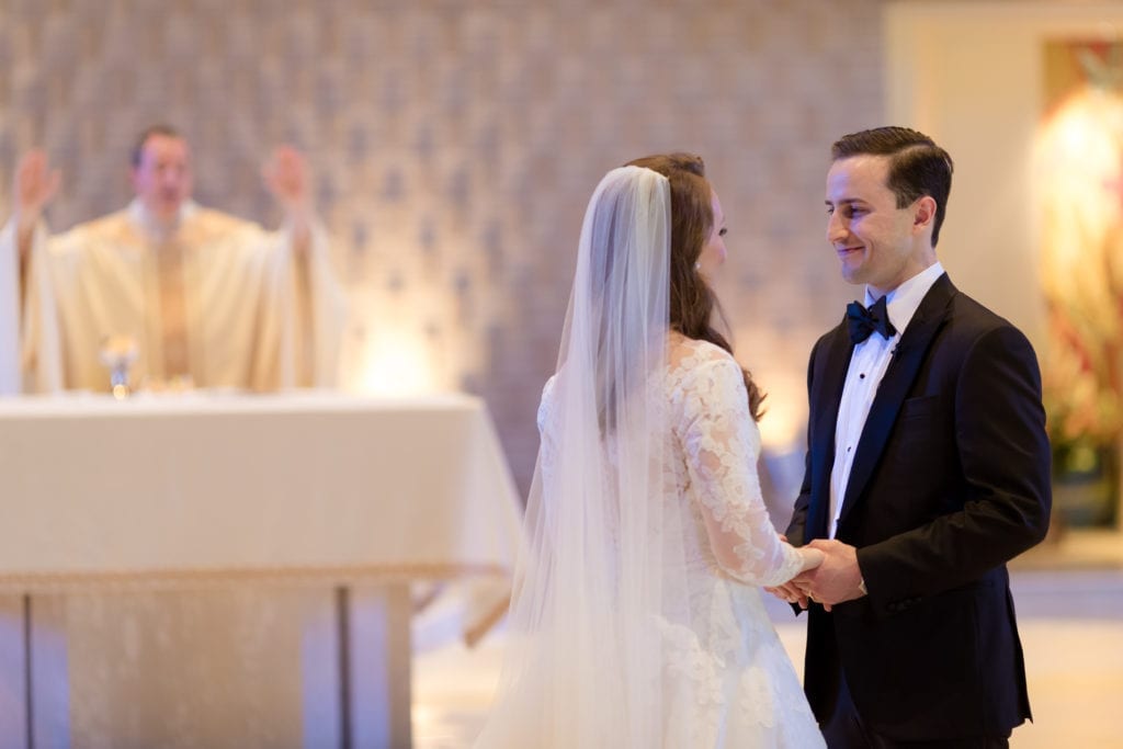 bride and groom embrace at the alter, L'Fay Bridal veil