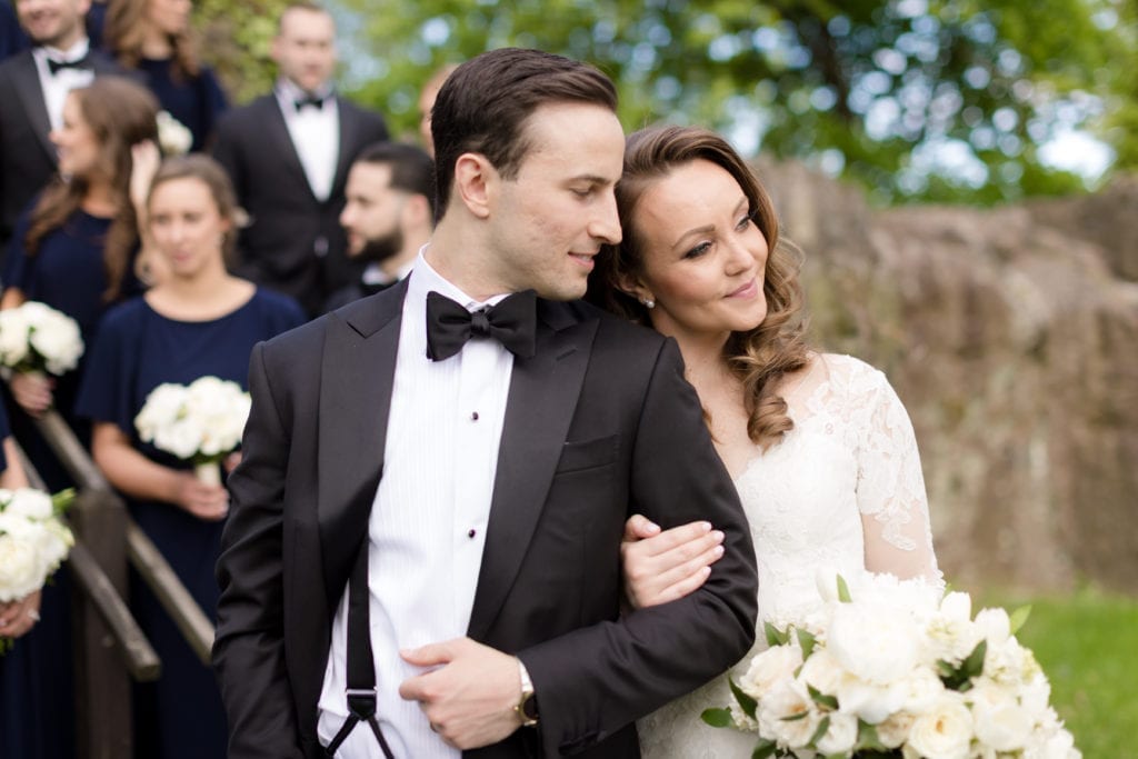 bride and groom embracing, white wedding bouquet 