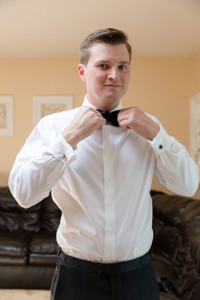 groom putting on his bowtie, groom getting ready for his wedding day