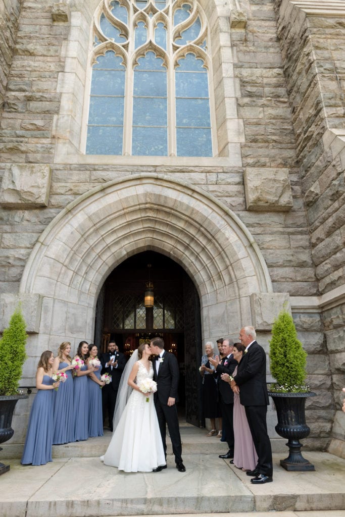 bride and groom embracing, bride and groom outside of church