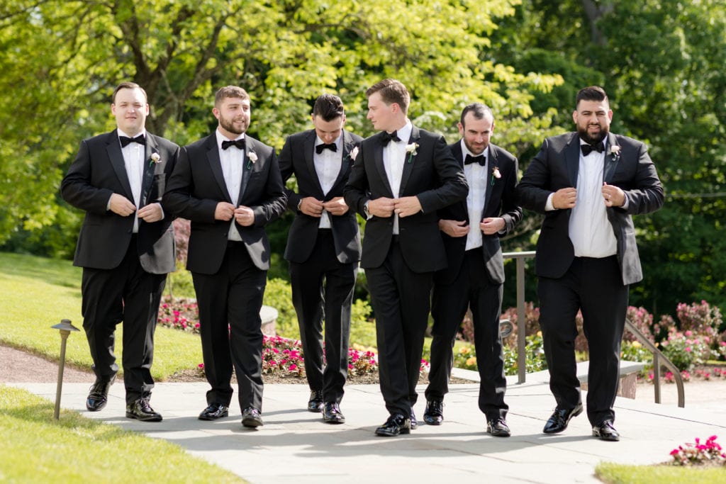 groomsmen buttoning up their jackets, The Black Tux