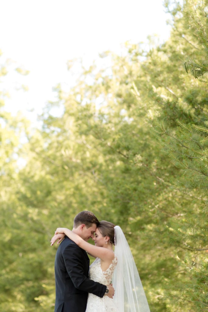 bride and groom hugging in front of lush trees, new jersey wedding venues