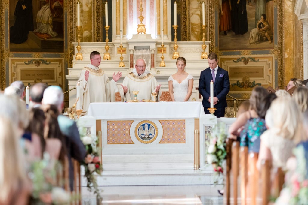 bride and groom performing traditional catholic wedding ceremony rituals