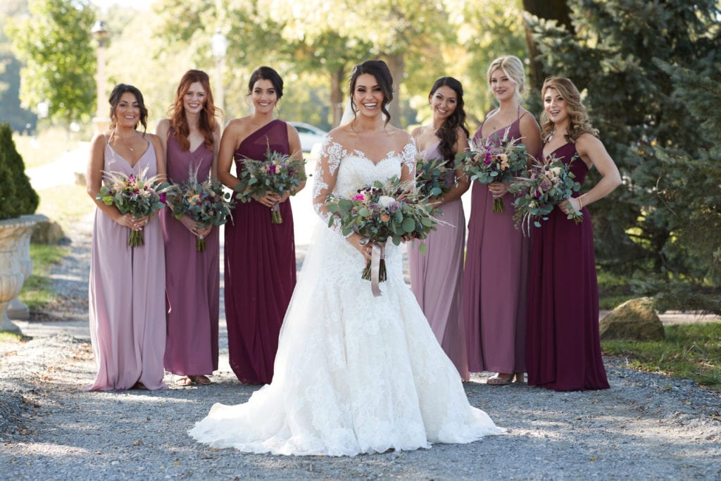 bride standing with her bridesmaids, dirt road wedding photos