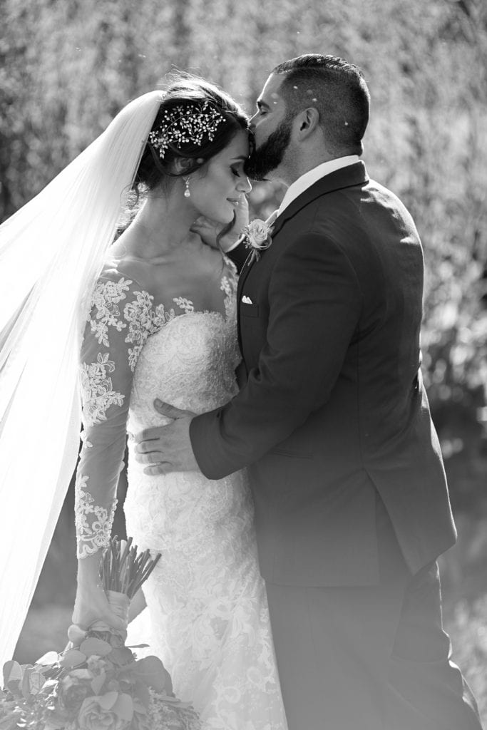 groom kissing brides forehead