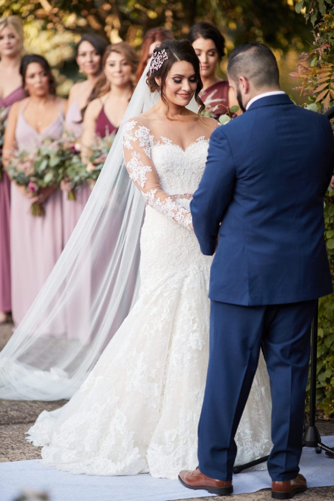 groom putting rings on his bride