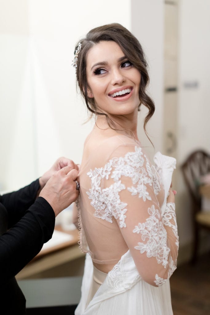 bride getting into her Pronovias wedding dress, long sleeve lace wedding dress bodice