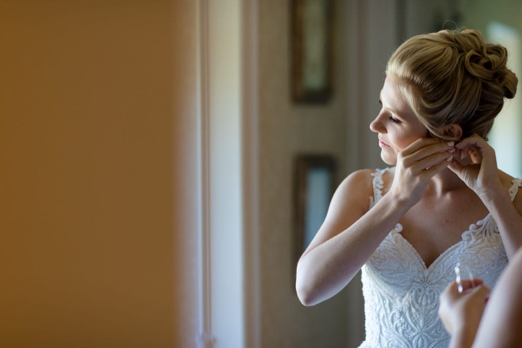 bride putting on earrings