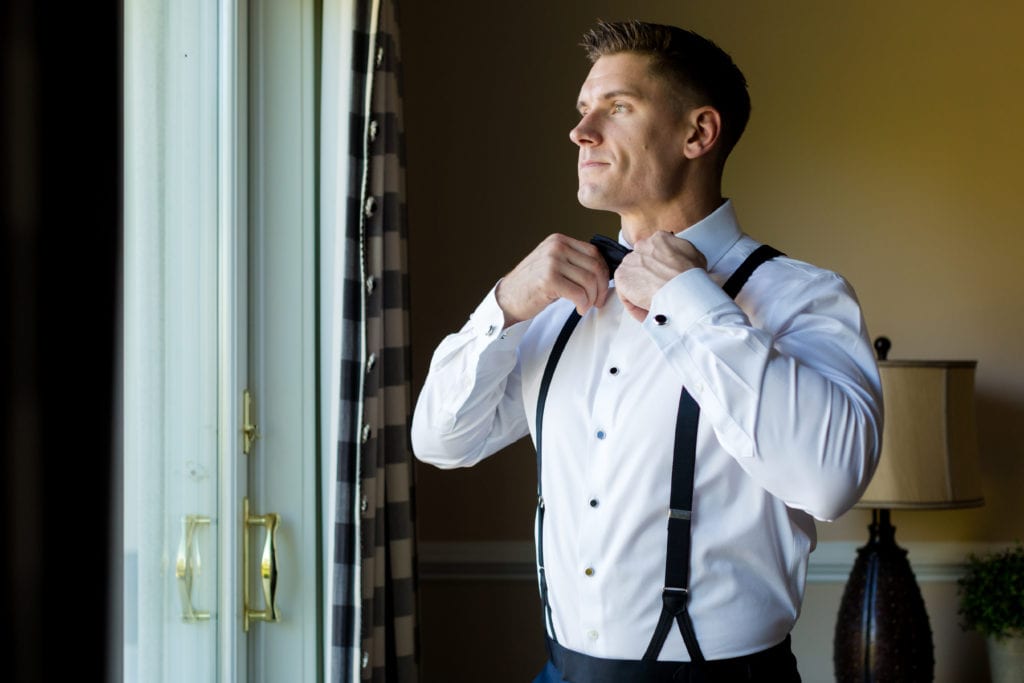 groom putting on bowtie 