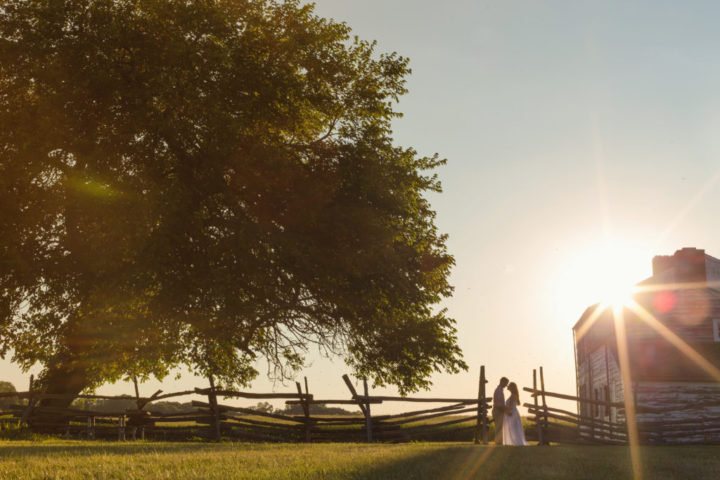 bride and groom at barn farm wedding sunny day flare. Photo by Vanessa Joy Photography.