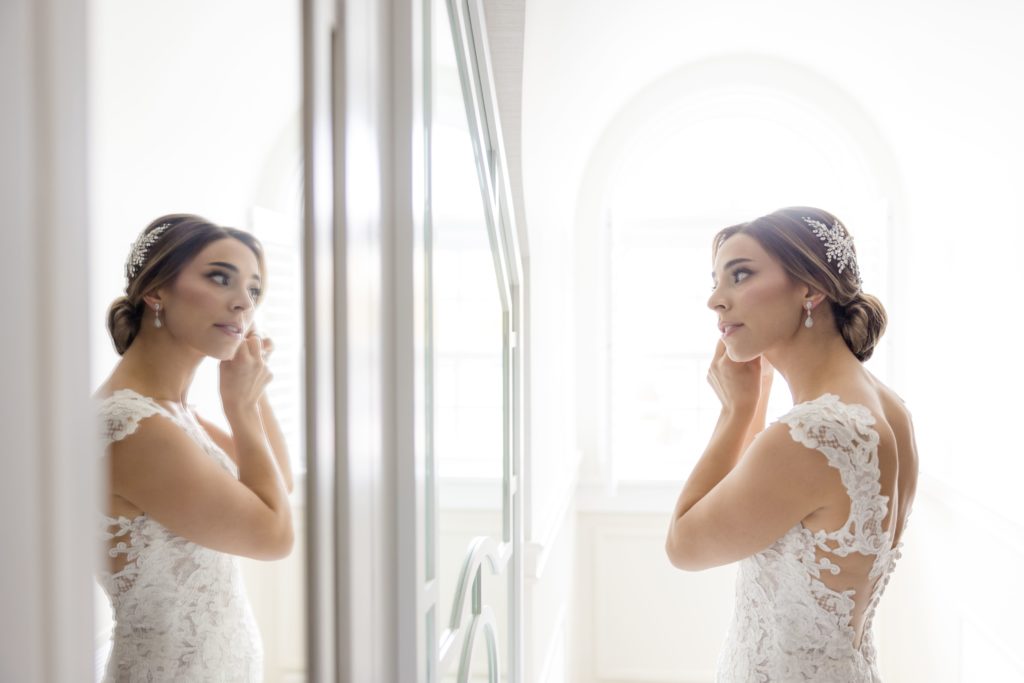 bride puts on her diamond earings