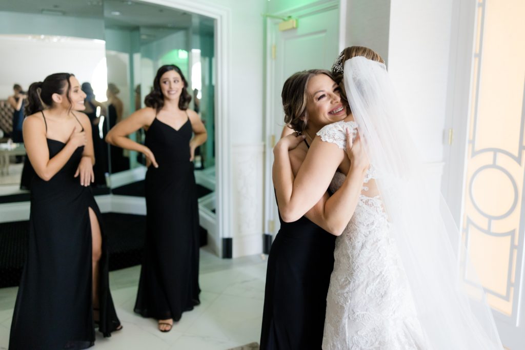 Bridesmaid hugs bride, bridal preparations