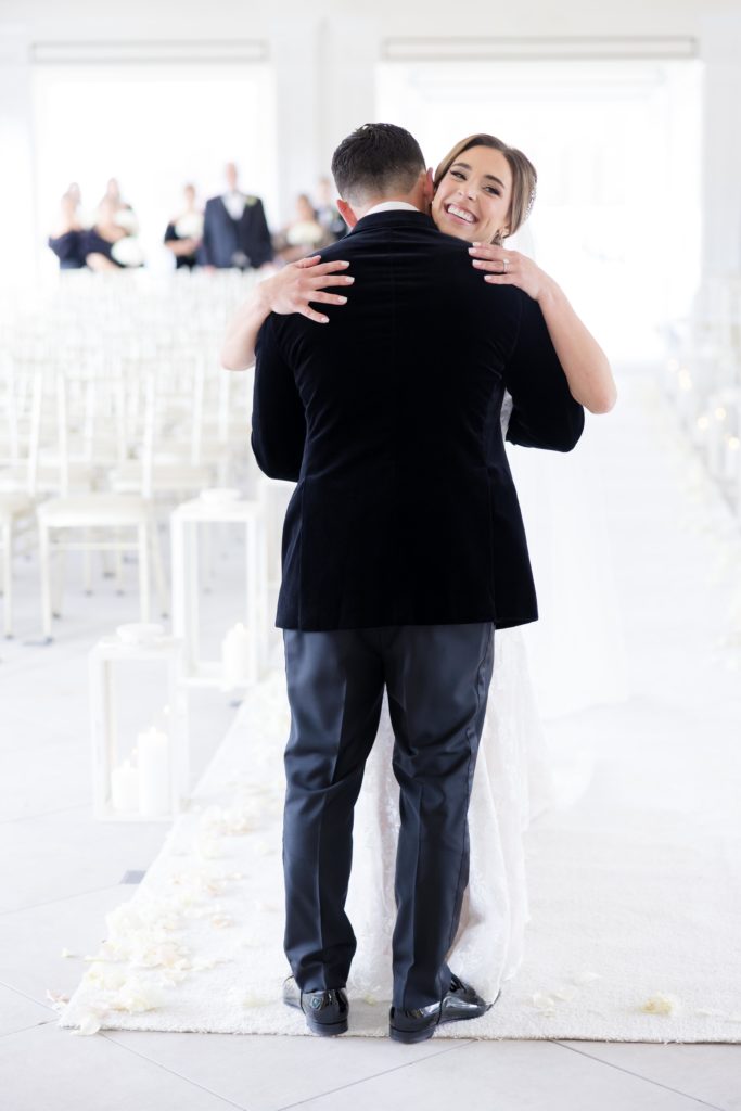 bride and groom hug on their first look at the wedding ceremony hall