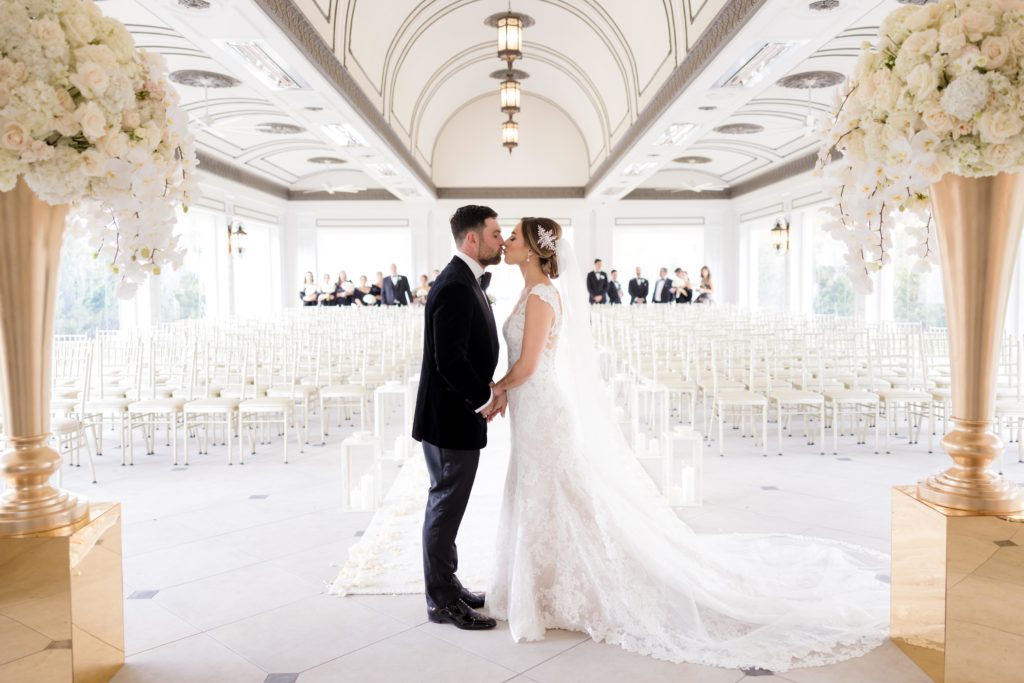 bride and groom kiss at their wedding ceremony hall at Shadowbrook At Shrewsbury