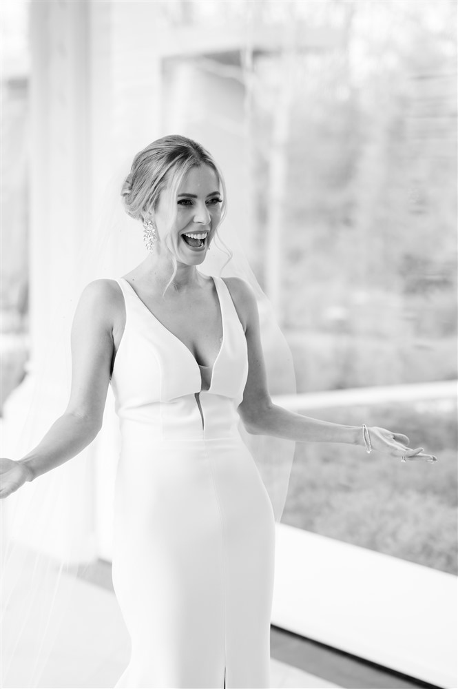 bride showing first look dress to groom