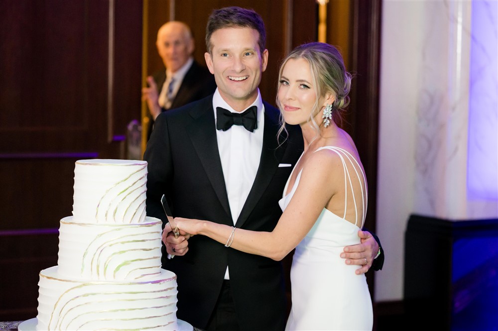 bride and groom cutting wedding cake