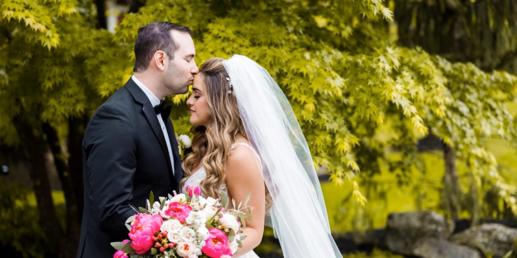 groom giving bride forehead kiss