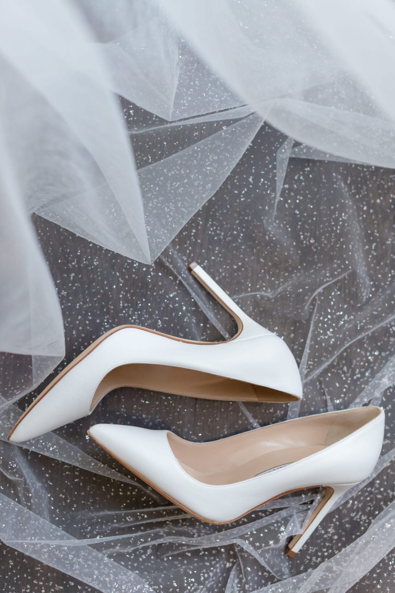 White pointed-toe pumps on a sparkling tulle veil